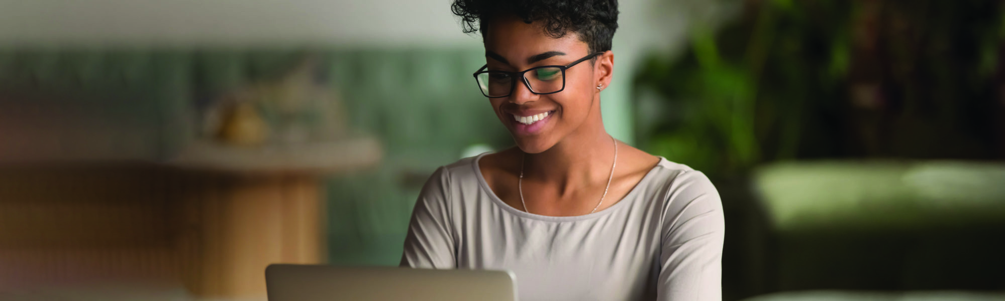 Fröhliche Afroamerikanerin beim Lernen an ihrem Laptop