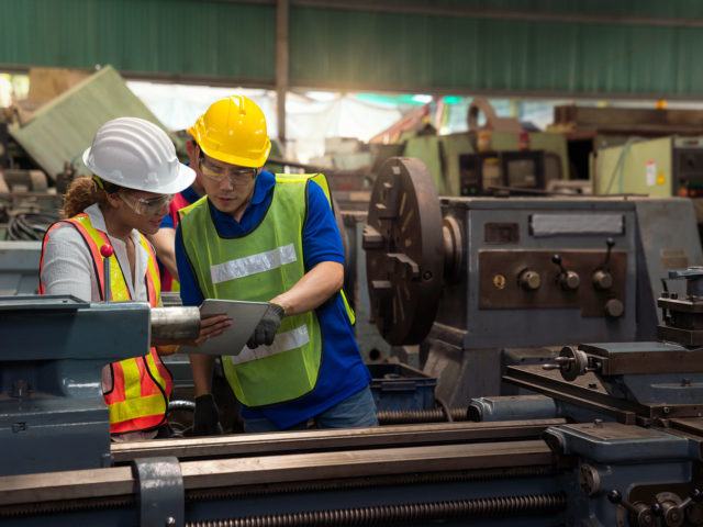 Arbeiter sehen sich Pläne an