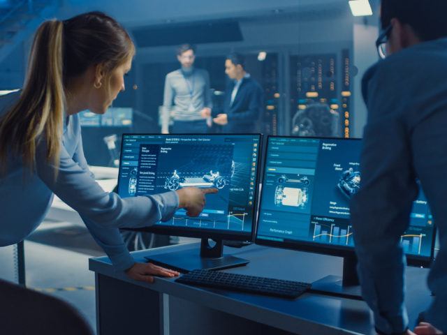 Ingenieure besprechen das 3D-CAD-Software-Render eines Elektrokonzeptfahrzeugs