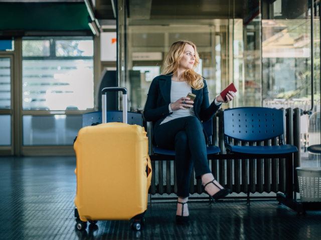 Geschäftsfrau am Flughafen wartet auf ihren Abflug