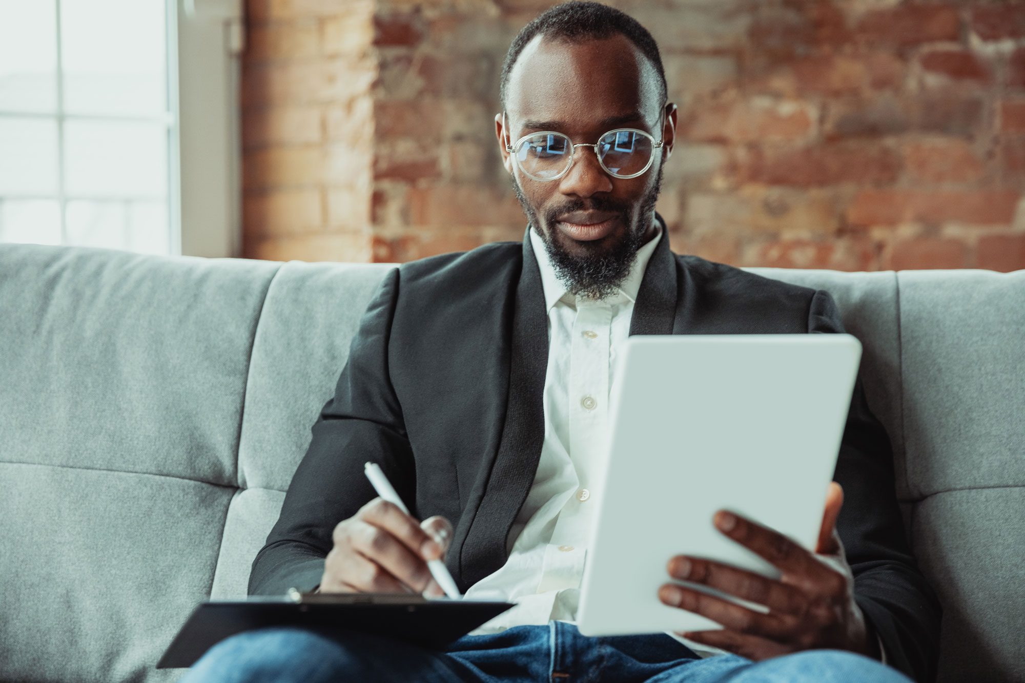 Afroamerikanischer Geschäftsmann am Laptop, Tablet