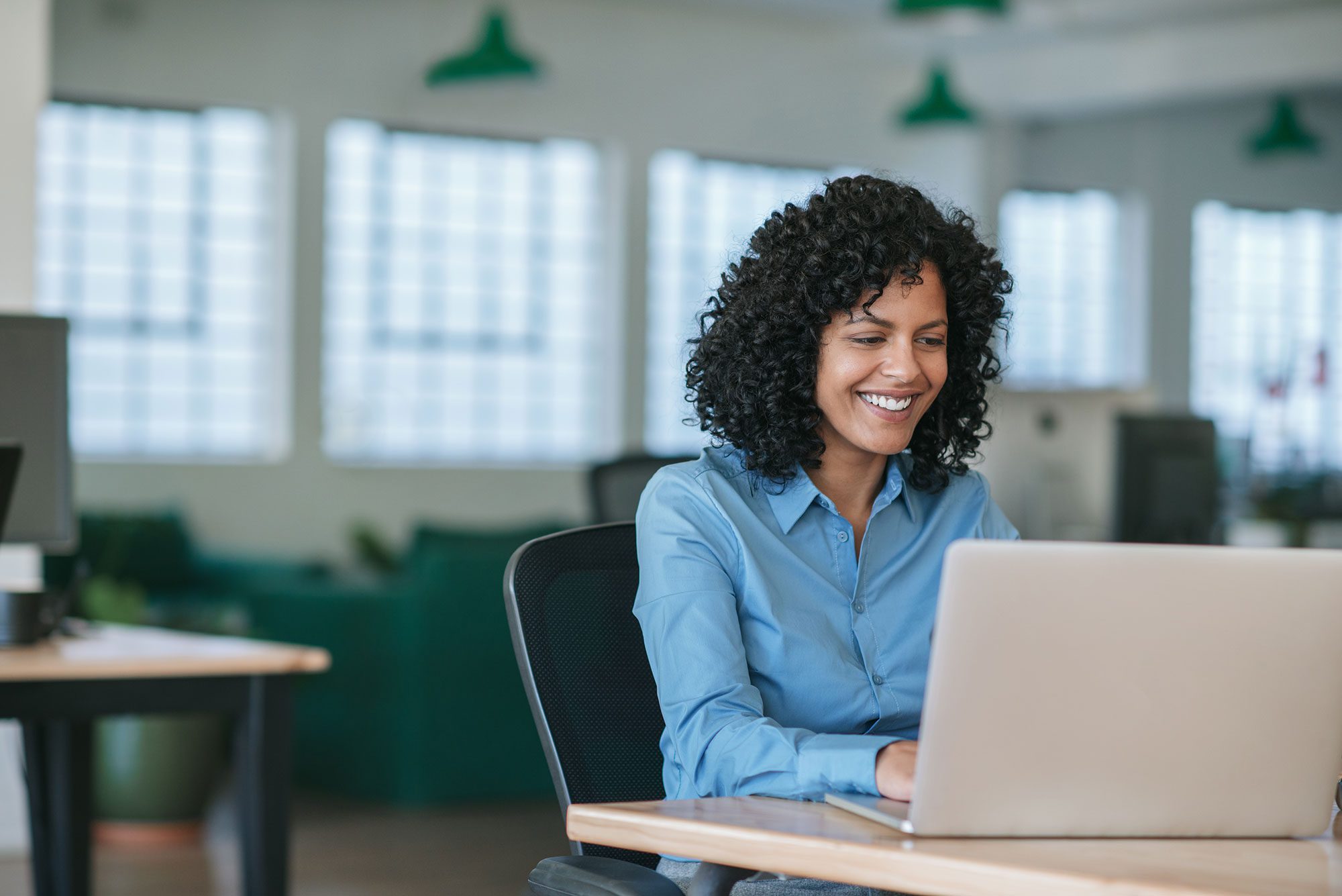 Junge afroamerikanische Frau arbeitet an einem Laptop